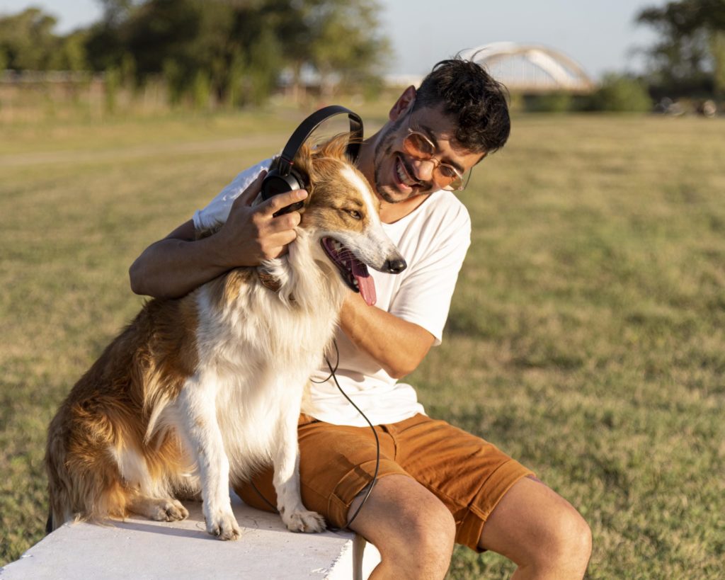 young-man-with-dog-seaside-with-headphones