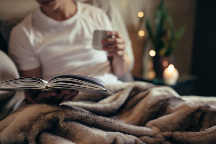 Man on bed reading book