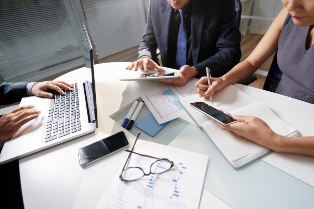 Business people sitting at office desk working on project