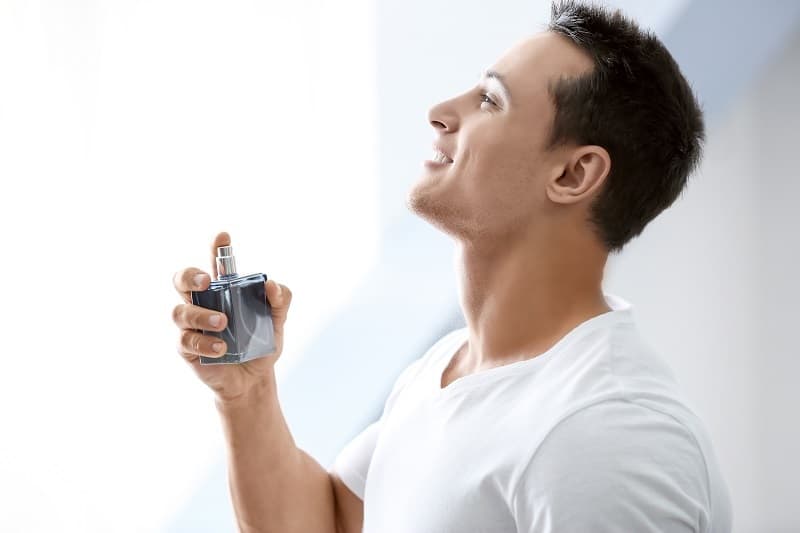 man spraying parfume