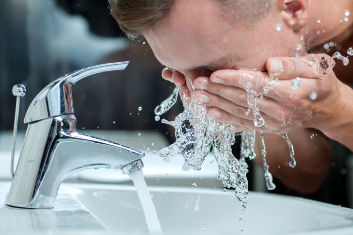 man washing face