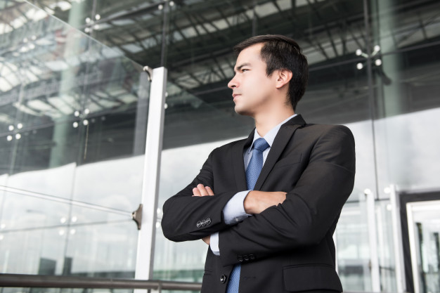 man in dark gray suit crossing his arms
