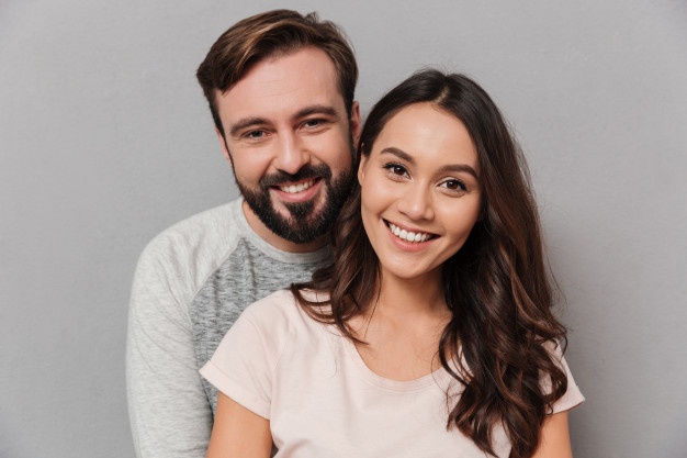 Laughing brunette man expressing love while posing with girlfriend. 