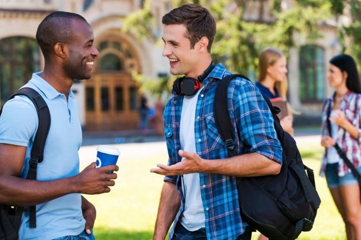 Two young men talking to each other and smiling 