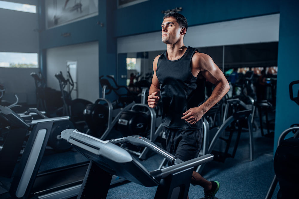 Male athlete workout on running exercise machine.