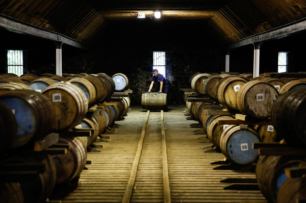 An employee moves a wooden cask of Chivas Regal blended Scotch whisky,