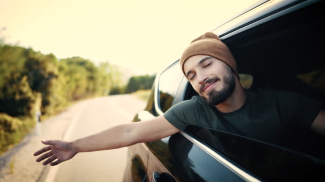 Man Enjoying Wind Through Window Of The Car