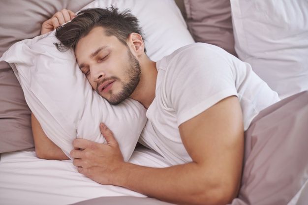 Exhausted man sleeping in his bed 