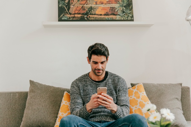 Man browsing smartphone in living room 