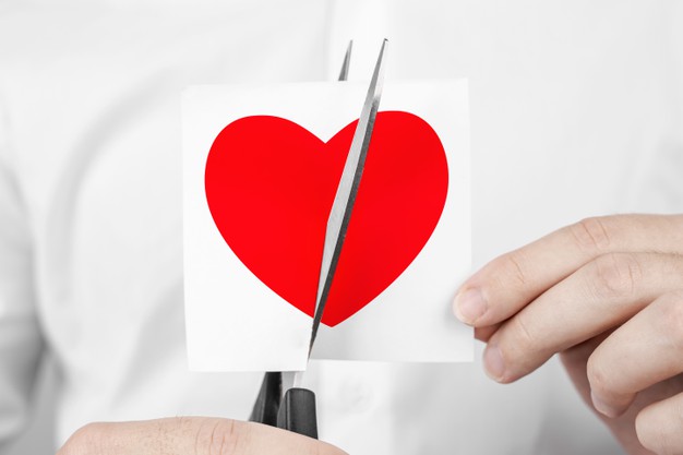 man cuts heart shape sticker