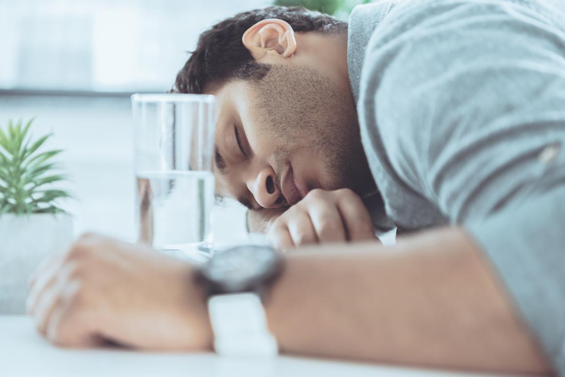 Tired young man sleeping at table