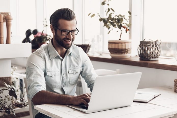 Smiling man working on computer at desk in office