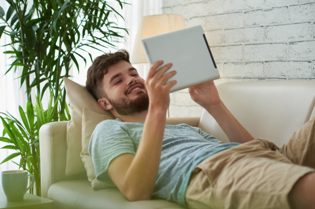 man spending his leisure time reading ebook 