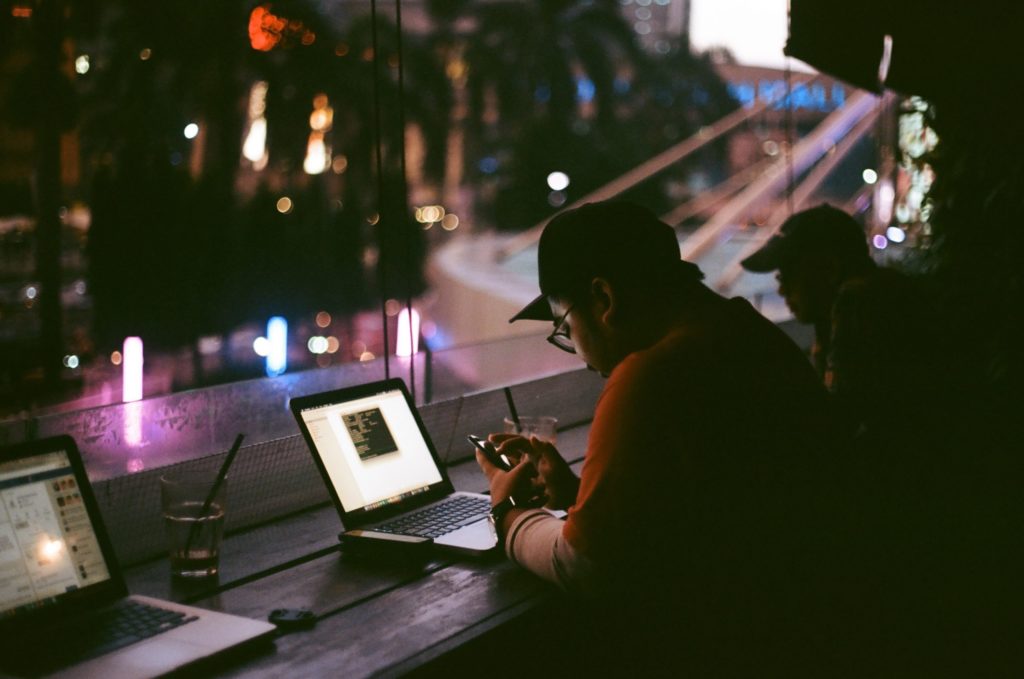 Man in a coffee shop looking at cell phone