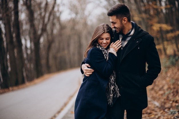 Young couple together walking in an autumn park 