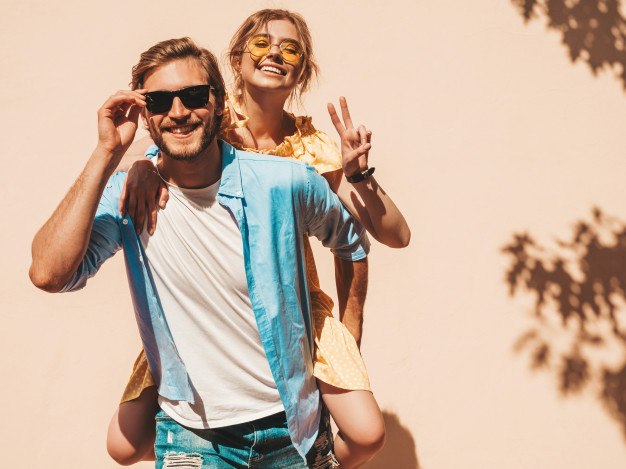 Portrait of smiling beautiful girl and her handsome boyfriend. woman in casual summer dress and man in jeans