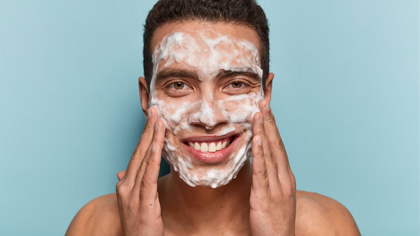 man washing face with facial foam