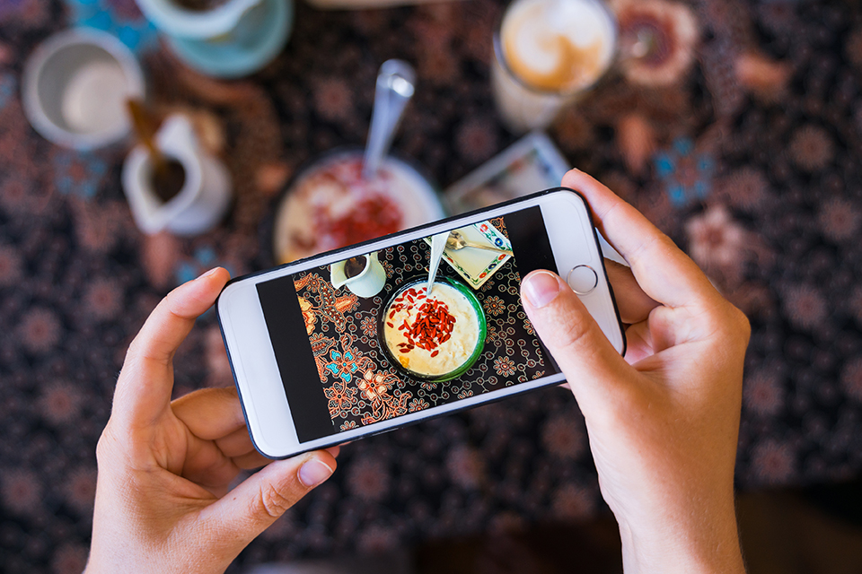  man using smart phone taking photo which take a picture food