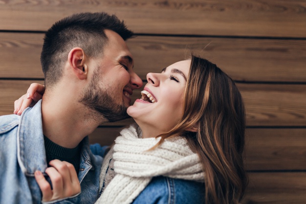 Laughing brunette man expressing love while posing with girlfriend. 