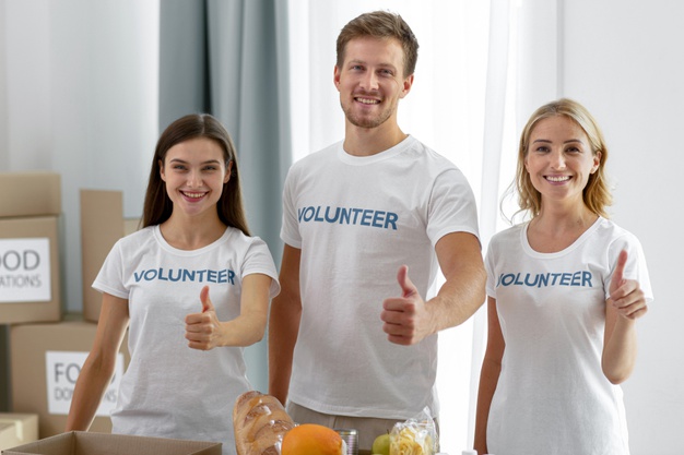 Group of volunteers doing the thumbs up sign 