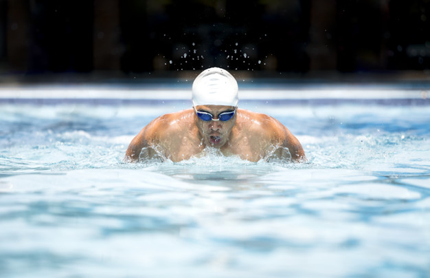 Swimmer in cap and glasses in swimming pool- healthy lifestyle