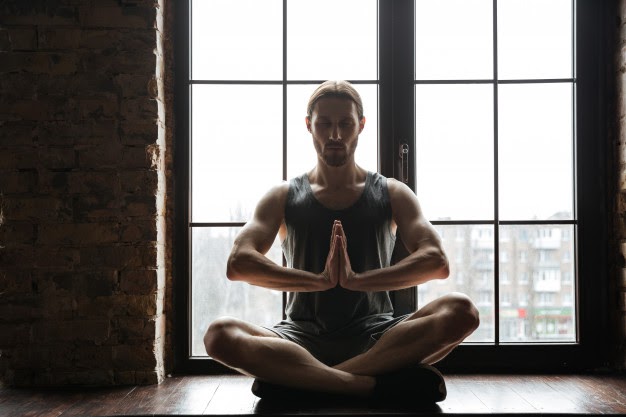 young sportsman meditating in lotus pose