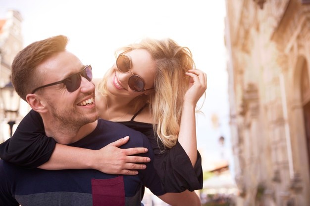 Cheerful man carrying his beloved girl 