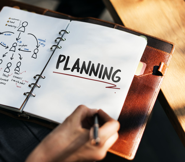 man writing and planning in his journal