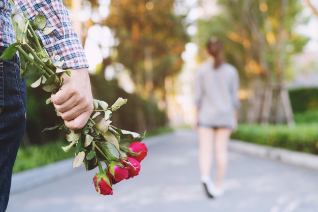 young man carrying red roses for his girlfriend