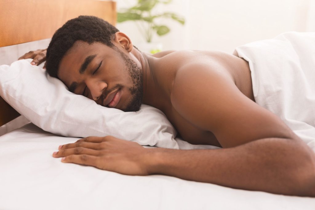 Man sleeping on bed in bedroom at home