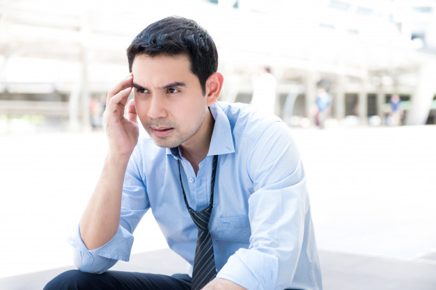 Broke jobless stressed asian businessman sitting outdoors