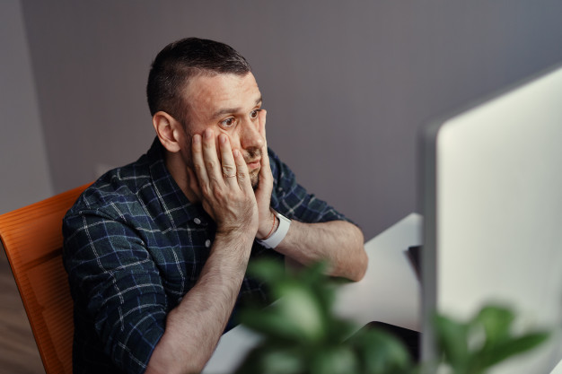 Concerned man touching face with two hands 