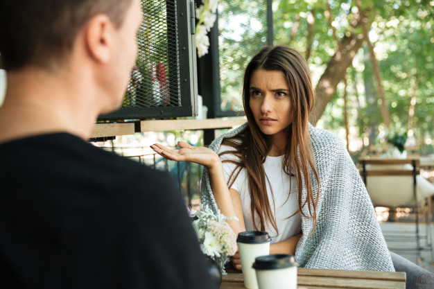 Confused young woman gesturing with hand 