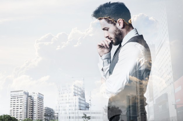Double exposure of young businessman and city