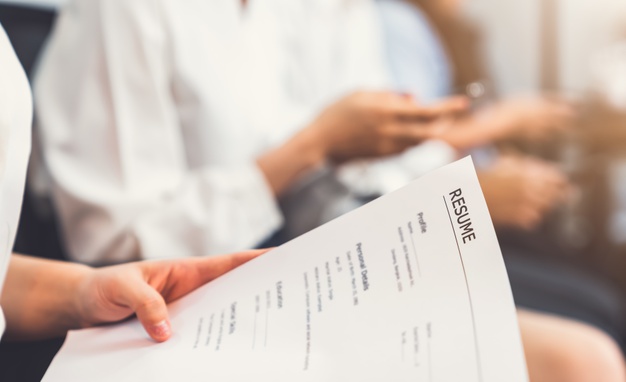 Hand holding document and submit resume to employer to review job application 