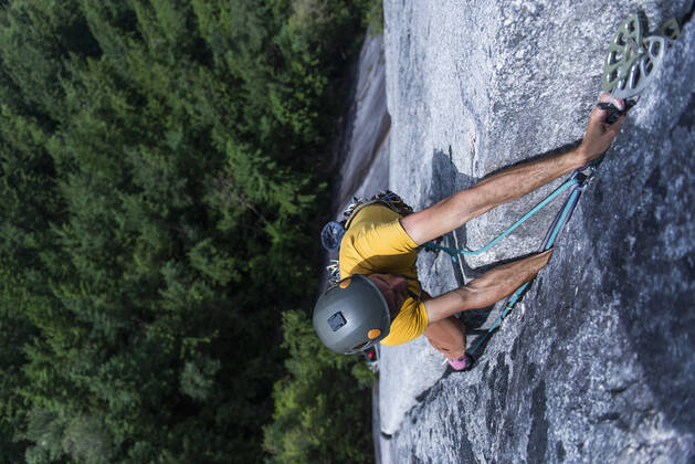 Male climber trying hard to grip small handholds on challen