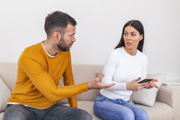 jealous boyfriend showing his cheating girlfriend her phone demanding explanation