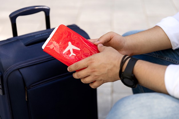 Man in casual clothes sitting on a bench with a luggage