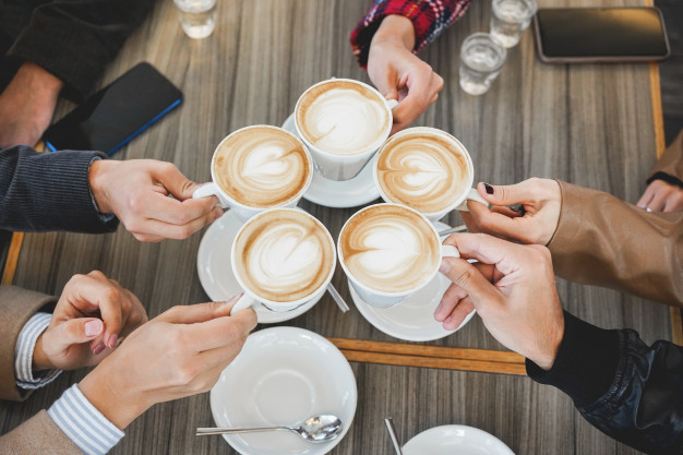 People drinking cappuccino inside vintage cafeteria 