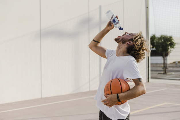 young man with basketball drinking water
