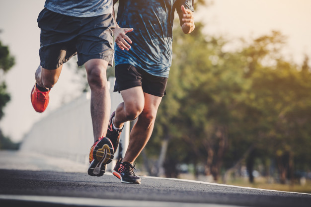 Young people runner running on running road in city park