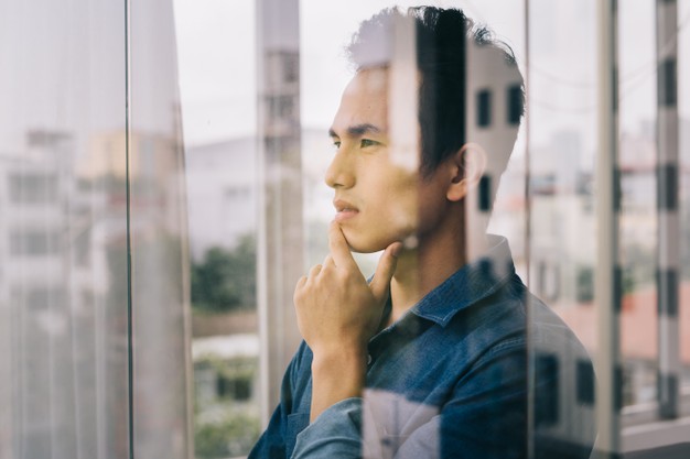 asian-man-was-contemplating-by-glass-door