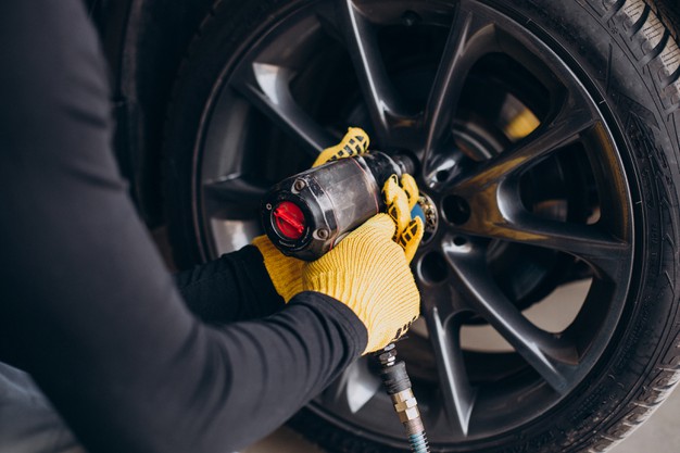 car-mechanic-changing-wheels-car