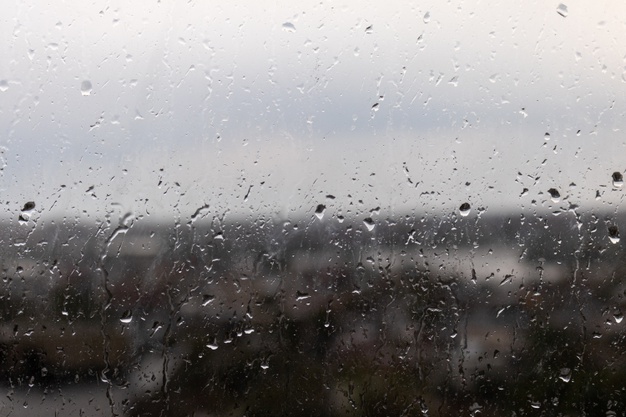 closeup-shot-window-rainy-gloomy-day-raindrops-rolling-down-window
