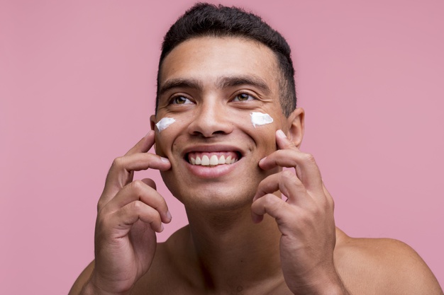 front-view-smiley-man-applying-cream-his-face