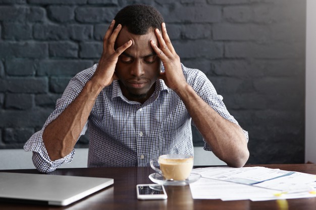 Frustrated young african-american businessman having bad headache