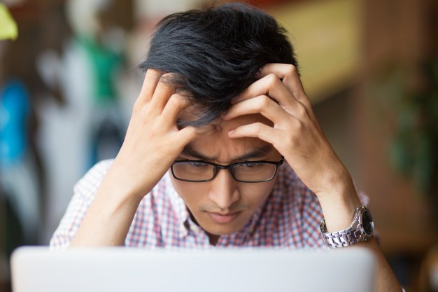 frustrated-young-asian-man-sitting-laptop