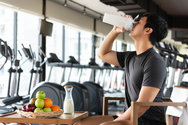  man drinking protein shake milk and many kind of fruits for nourishing body daily