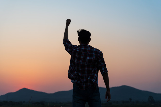 man-with-fist-air-during-sunset-freedom-courage-concept