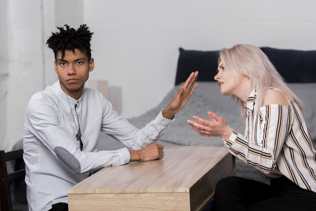 young man ignoring her girlfriend arguing with him